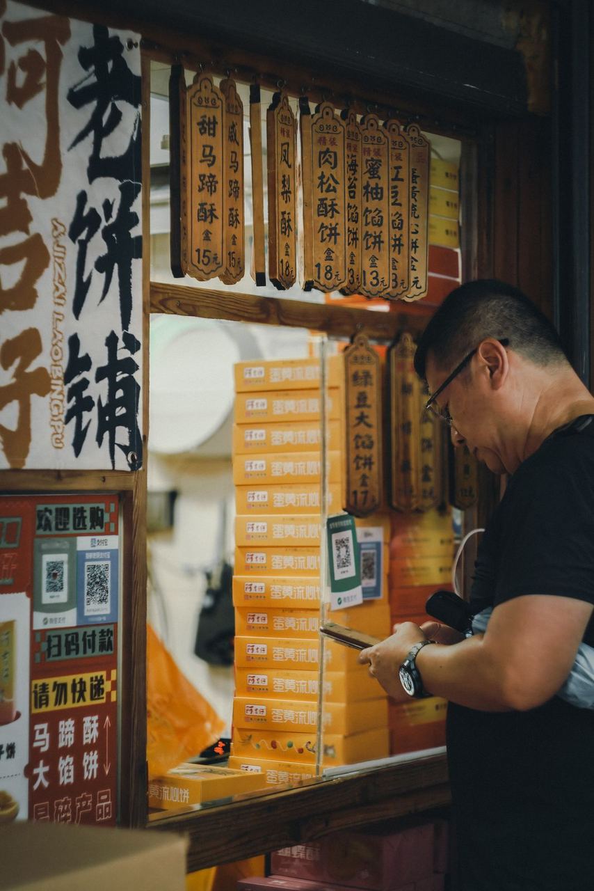 A traveller paying at a street food stall by scanning a QR code on their phone