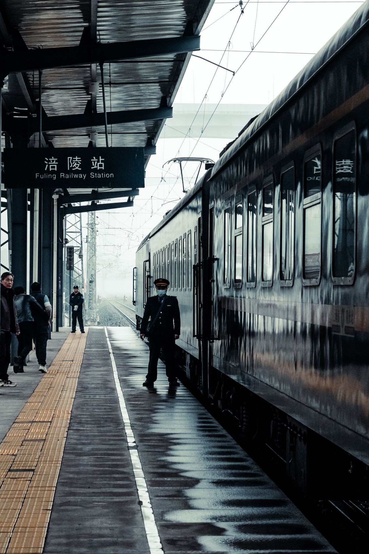Passengers and a conductor on a high-speed rail platform