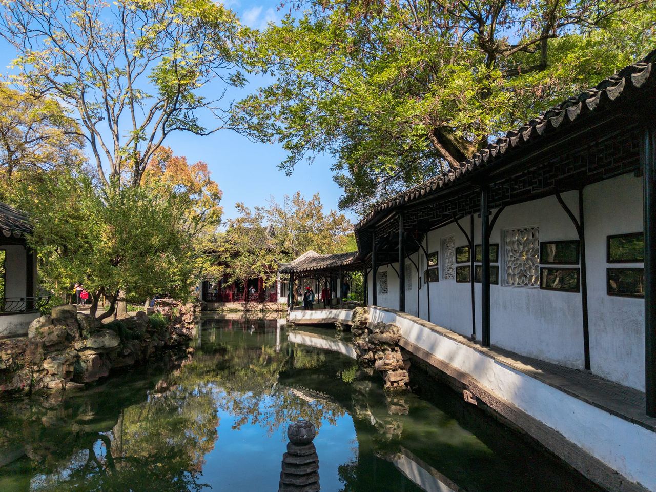 A classical garden pavilion reflected in a lotus pond