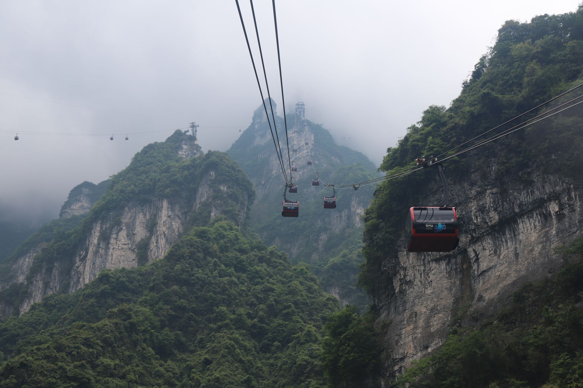Cable cars climbing Tianmen Mountain through the mist