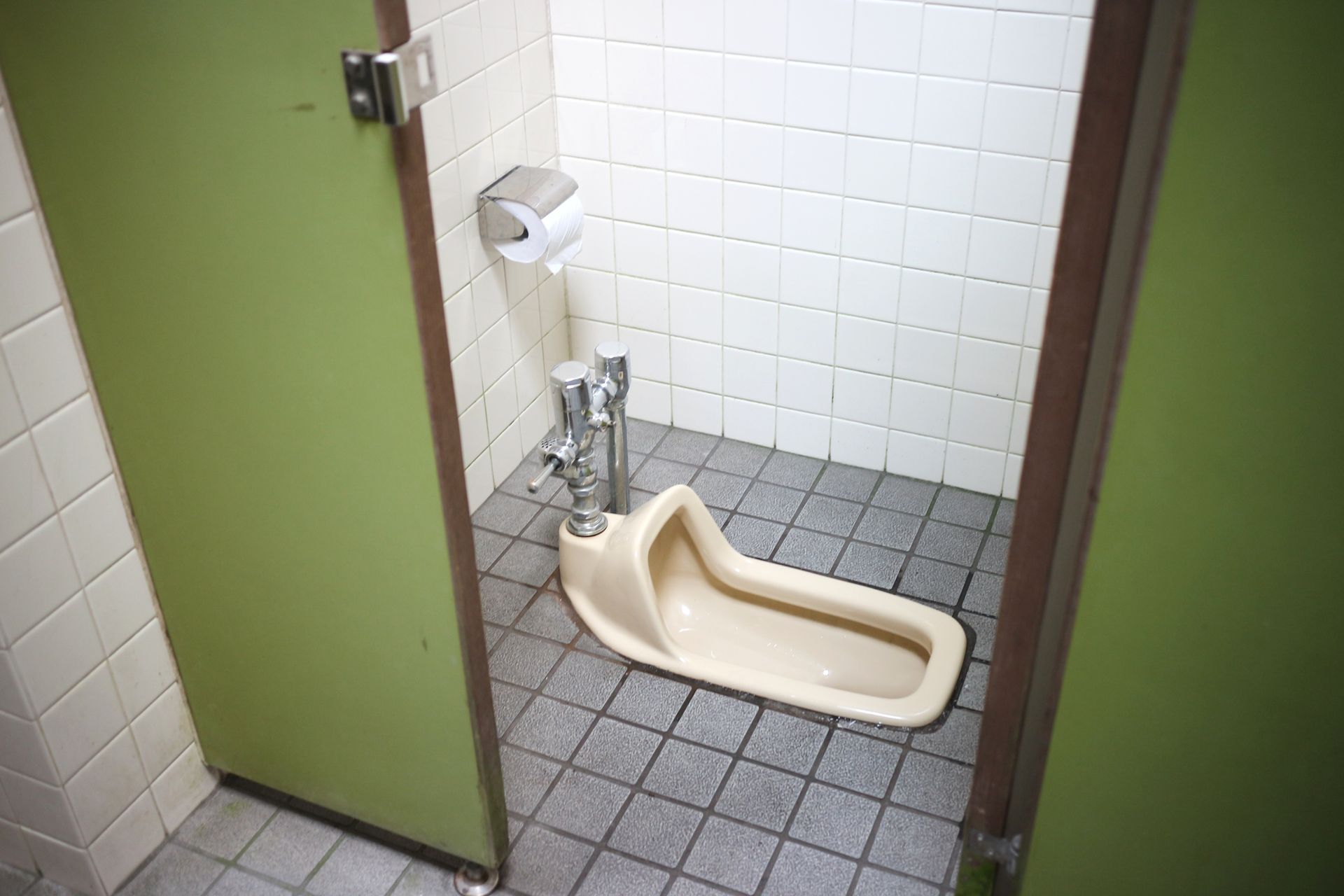 A squat toilet in a tiled public restroom